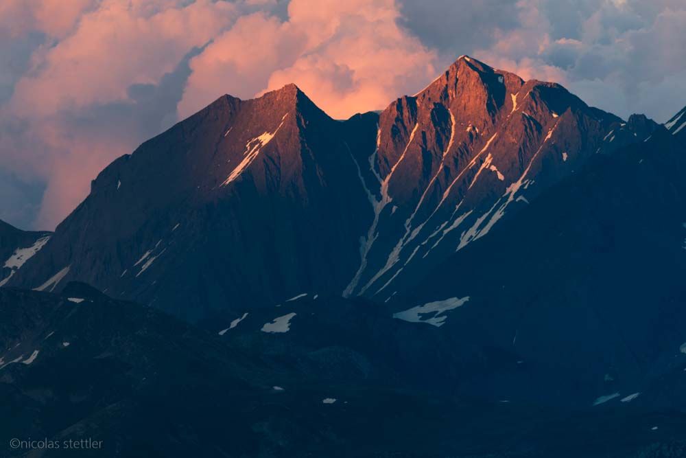 Ein Berg im Wallis wird von der untergehenden Sonne angeleuchtet.